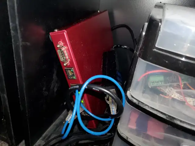 A PC Engines alix2 computer connected to a power over ethernet splitter sitting on a shelf